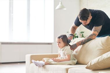 Caring father combing little daughter's hair